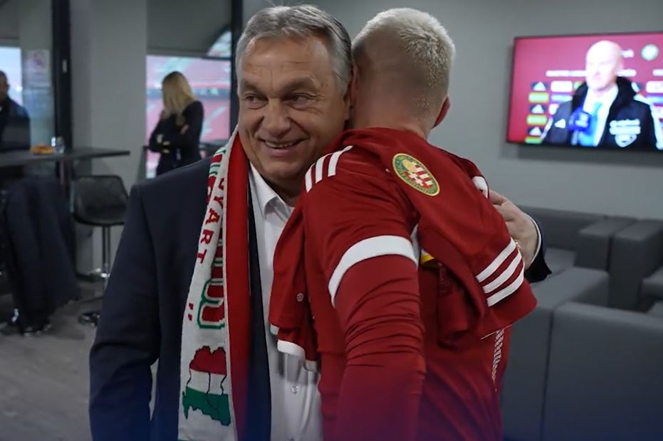 Viktor Orban wearing nationalist scarf embracing player